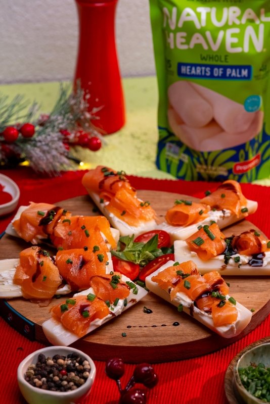 Holiday appetizer bites made with hearts of palm topped with lemon cream cheese, smoked salmon, and fresh herbs.